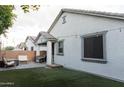 Private backyard with manicured turf, patio furniture, and charming string lights at 14344 W Hackamore Dr, Surprise, AZ 85387
