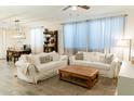 Bright living room with white sofas, neutral rug, tile flooring, and lots of natural light at 14344 W Hackamore Dr, Surprise, AZ 85387