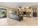 Spacious living room with a sleek media center, neutral tones, and sliding glass doors to the backyard at 14426 W Becker Ln, Surprise, AZ 85379