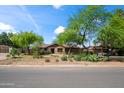 Inviting one-story home with desert landscaping including a mature tree in front at 1720 W Elm St, Phoenix, AZ 85015