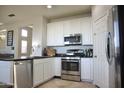 Well-appointed kitchen with stainless steel appliances, tile flooring, and white cabinetry at 20217 W Desert Bloom St, Buckeye, AZ 85326