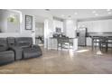 Open concept living room view shows tile floors, kitchen bar, and office space at 20217 W Desert Bloom St, Buckeye, AZ 85326