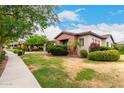 Picturesque single-Gathering home featuring desert landscaping, flowering bushes, mature trees, and well-maintained grounds at 20532 W Summit Pl, Buckeye, AZ 85396