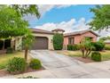 Beautifully landscaped front yard, mature desert trees, and a private gated entry enhance the curb appeal of this desert home at 20532 W Summit Pl, Buckeye, AZ 85396