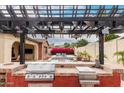 Close-up of an outdoor kitchen area complete with grill and sink, perfect for outdoor cooking and entertaining by the pool at 20532 W Summit Pl, Buckeye, AZ 85396