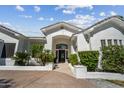 Elegant home entrance with a white brick facade, arched entryway, and landscaped garden at 210 E Cactus Wren Dr, Phoenix, AZ 85020