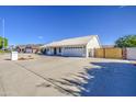 Single-story home with a white tile roof, a two-car garage, and a spacious driveway at 2317 E Lynwood St, Mesa, AZ 85213