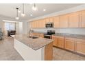 Bright kitchen features a granite island with sink, stainless appliances, and seamless flow into the dining area at 24580 N 144Th Ave, Surprise, AZ 85387