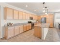 Well-designed kitchen features abundant cabinetry, a large island, and modern lighting fixtures at 24580 N 144Th Ave, Surprise, AZ 85387