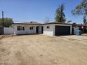 Charming single-story home featuring a well-maintained front yard, a dark two-car garage door, and a covered front porch at 2833 W Marlette Ave, Phoenix, AZ 85017