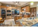 Spacious kitchen featuring stainless steel appliances, custom wood cabinets, and granite countertops at 30330 N 77Th Pl, Scottsdale, AZ 85266
