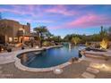 Stunning backyard pool and spa featuring rock accents and night lighting near the main house at 30330 N 77Th Pl, Scottsdale, AZ 85266