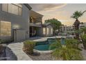 Inviting backyard pool with lush tropical landscaping, covered patio, and elegant stonework, perfect for outdoor enjoyment at 3202 E Orange Dr, Phoenix, AZ 85018
