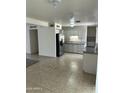 Open-concept kitchen featuring neutral cabinets, stainless steel refrigerator, and tile flooring at 3608 W Hazelwood St, Phoenix, AZ 85019