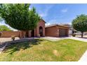 Charming single-story home with a well-maintained front yard, arched entry, and a two car garage at 40275 W Art Pl, Maricopa, AZ 85138