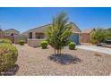 Well-maintained home with desert landscaping, a two-car garage, and a cozy front porch at 40441 W Hillman Dr, Maricopa, AZ 85138