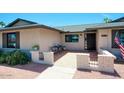 Inviting front porch with a cozy seating area and charming brick accents and an american flag at 4079 E Shangri La Rd, Phoenix, AZ 85028