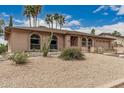 Home featuring arched windows, neutral stucco, low maintenance desert landscaping, and a walkway to the entry at 4229 E Pearce Rd, Phoenix, AZ 85044