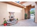 Charming fountain in the front patio with a brick floor in a neutral stucco patio at 4756 E Ironhorse Rd, Gilbert, AZ 85297