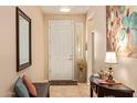 Inviting entryway featuring a white door, decorative mirror, ceramic tile, and a bench at 6482 S Claiborne Ave, Gilbert, AZ 85298