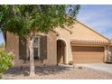 View of the front exterior with desert landscaping, featuring an attached two-car garage and neutral color scheme at 6482 S Claiborne Ave, Gilbert, AZ 85298