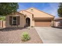 Charming single-story home with desert-landscaped front yard, an arched entryway, and attached two-car garage at 6482 S Claiborne Ave, Gilbert, AZ 85298