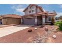Exterior view of a home featuring a two-car garage and desert landscaping at 6853 S Roosevelt St, Tempe, AZ 85283