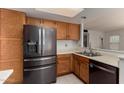 Spacious kitchen featuring stainless steel refrigerator and sink with wood cabinets at 6853 S Roosevelt St, Tempe, AZ 85283