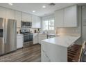 Bright kitchen features white cabinets, stainless steel appliances, a breakfast bar and wood look flooring at 6945 E Osborn Rd # E, Scottsdale, AZ 85251