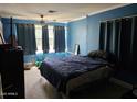 Cozy blue bedroom with natural light, a ceiling fan, and ample space at 723 E Moreland St, Phoenix, AZ 85006