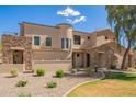 Charming home featuring stone accents, a tiled roof, a landscaped yard, and well manicured desert landscaping at 7445 E Eagle Crest Dr # 1061, Mesa, AZ 85207