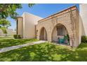 View of a townhome with an arched brick entry and green lawn under a clear blue sky at 7808 E Lewis Ave, Scottsdale, AZ 85257