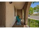Cozy front porch featuring brick arches, teal chair, and views of the neighborhood at 7808 E Lewis Ave, Scottsdale, AZ 85257