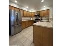 Well-maintained kitchen featuring stainless steel appliances, oak cabinets, and tile flooring at 8874 N 48Th Ln, Glendale, AZ 85302