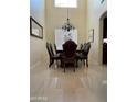 Elegant dining room with tile flooring, large window, chandelier, and dining table set for eight at 10426 W Roanoke Ave, Avondale, AZ 85392