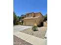 Exterior view of home showcasing a desert landscape, a driveway, and a two-car garage at 10426 W Roanoke Ave, Avondale, AZ 85392