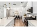 Modern kitchen with stainless steel appliances, white cabinets and an island, flowing into the dining area at 10956 E Thunderbolt Ave, Mesa, AZ 85212