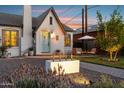 Quaint white brick home with a light blue door and a cozy outdoor seating area on a brick and gravel courtyard at 1111 E Coronado Rd, Phoenix, AZ 85006