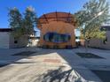 Community clubhouse entrance showcasing modern architecture and lush landscaping at 13282 E Verbina Ln, Florence, AZ 85132