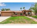Inviting home featuring a red tile roof, well-manicured lawn, and desert landscaping with mountain views at 15430 N 19Th Way, Phoenix, AZ 85022