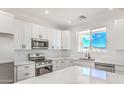 Bright, modern kitchen with white cabinetry, stainless steel appliances, and marble countertops at 16025 E Rancho Laredo Dr, Scottsdale, AZ 85262