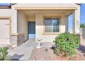 Charming front porch with a blue door, complemented by vibrant landscaping and a bird bath at 19365 N Pietra Dr, Maricopa, AZ 85138