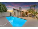 Sparkling backyard pool with lounge chairs, desert landscaping and sunset sky at 2018 E Balboa Dr, Tempe, AZ 85282