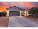 Inviting home exterior at twilight, featuring low-maintenance landscaping and a two-car garage at 203 S 190Th Ave, Buckeye, AZ 85326