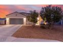 Inviting home exterior at twilight, featuring low-maintenance landscaping and a two-car garage at 203 S 190Th Ave, Buckeye, AZ 85326
