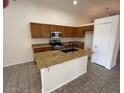 Bright kitchen features granite counters, wood cabinets, and a central island with a sink at 21192 N 80Th Ln, Peoria, AZ 85382