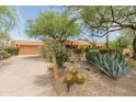 Attractive single-story home with desert landscaping, a spacious driveway, and a two-car garage at 23240 N Country Club Trl, Scottsdale, AZ 85255
