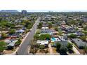 This aerial view showcases a neighborhood with tree-lined streets and a home with a backyard pool at 2545 N 14Th St, Phoenix, AZ 85006
