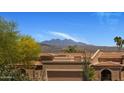 Exterior view of home showing tile roof, 2-car garage and mountain view in the background at 25609 N Forest Rd # 13, Rio Verde, AZ 85263