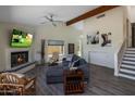 Comfortable living room boasts a fireplace, ceiling fan, and plush seating, with stair access nearby at 25609 N Forest Rd # 13, Rio Verde, AZ 85263